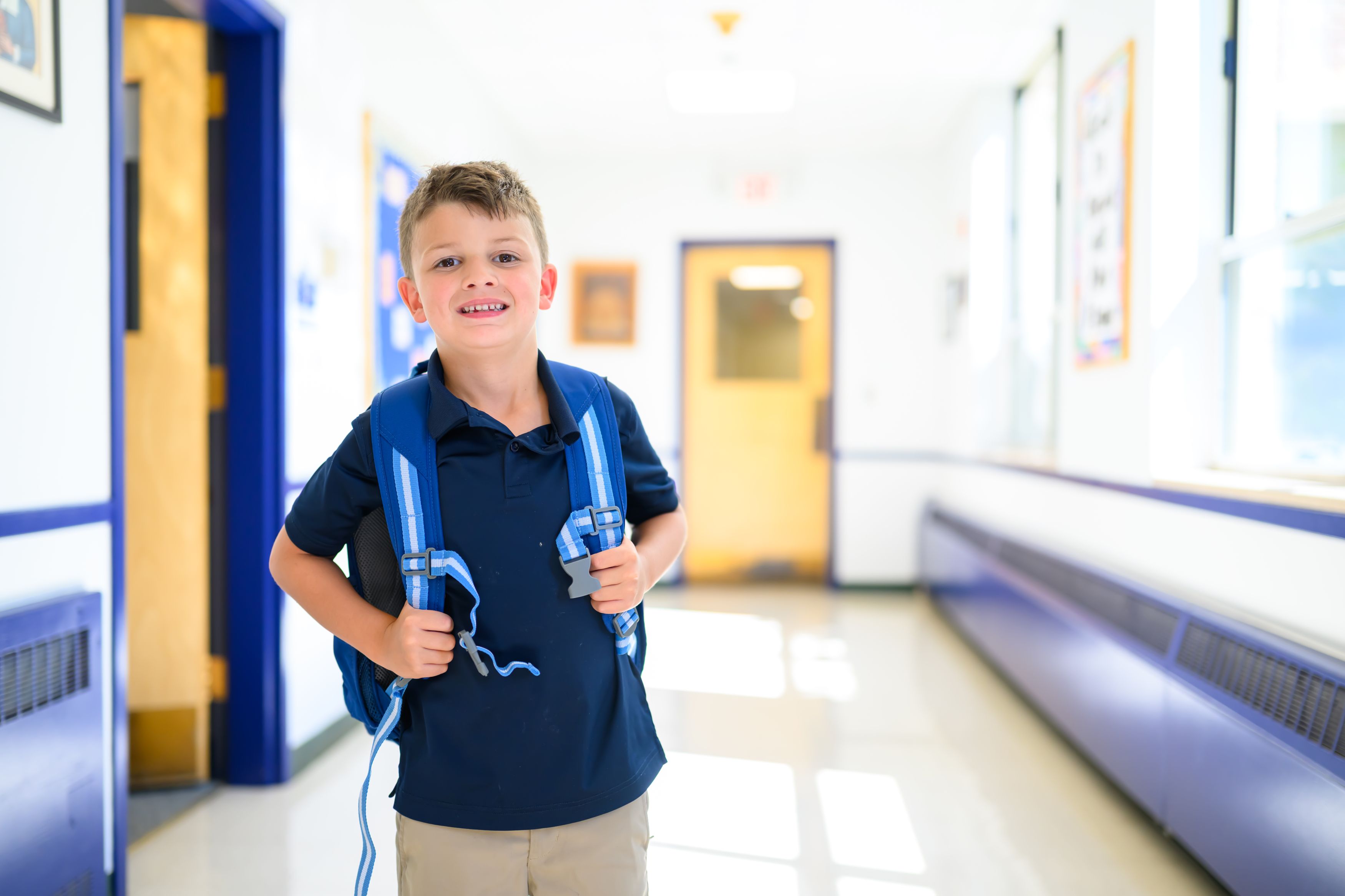 Student with backpack in school hallway